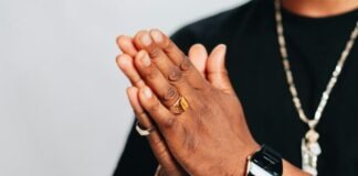 Top Trends in Sports Ring Designs for 2024 a man in a black shirt is holding his hands together