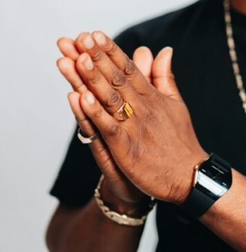 Top Trends in Sports Ring Designs for 2024 a man in a black shirt is holding his hands together