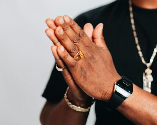 Top Trends in Sports Ring Designs for 2024 a man in a black shirt is holding his hands together