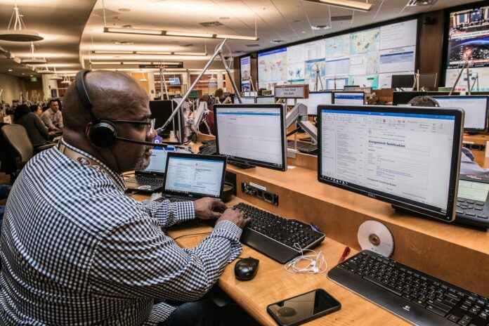 Photo by CDC man in black and white checkered dress shirt using computer