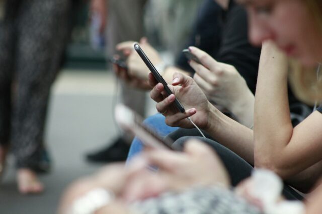 Photo by ROBIN WORRALL person holding black phone