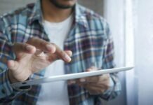 How to Register on 1WIN: A Step-by-Step Guide man in red and blue plaid button up shirt holding white tablet computer