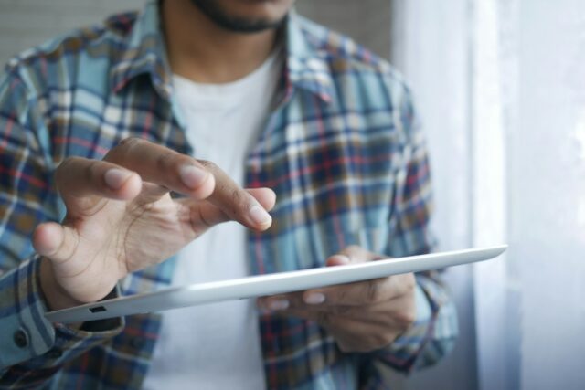 Photo by Towfiqu barbhuiya man in red and blue plaid button up shirt holding white tablet computer