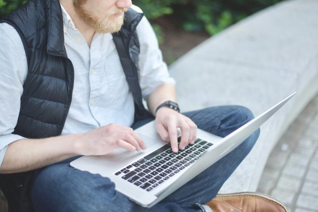 Photo by Lucian Novosel man using MacBook while sitting on bench