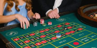 The Ultimate Experience in Online Casino Malaysia: Top Games and Tips Captivating scene of a casino roulette table with gamblers placing their bets.
