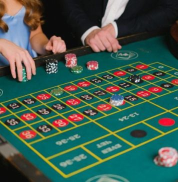 The Ultimate Experience in Online Casino Malaysia: Top Games and Tips Captivating scene of a casino roulette table with gamblers placing their bets.