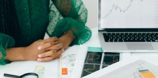 How AI Accelerates Landing Page Creation A person analyzes financial charts and graphs at a desk, indicating business trading activity.