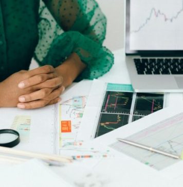 How AI Accelerates Landing Page Creation A person analyzes financial charts and graphs at a desk, indicating business trading activity.