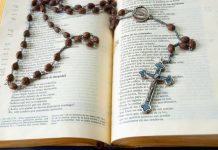 Catholic Books That Bring Reflection Into Everyday Life silver cross pendant necklace on book page